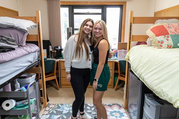 two students smiling in their residence hall room