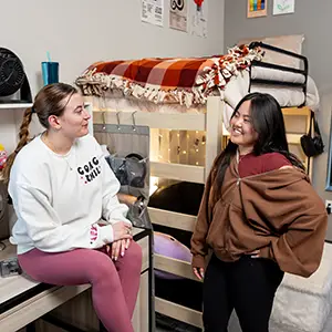 two female students in a decorated residence hall room