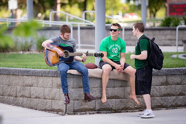 students gathering playing guitar