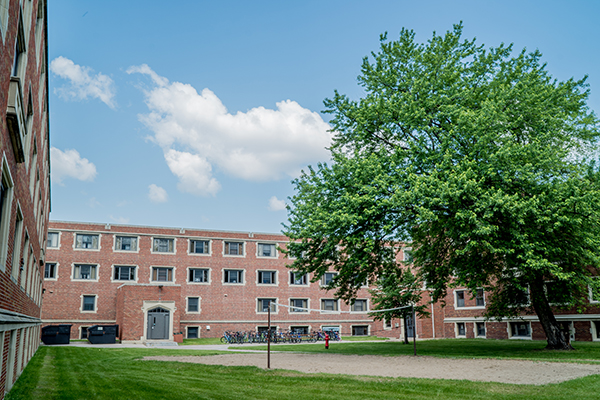 smith hall in the summer with tree & volleyball court