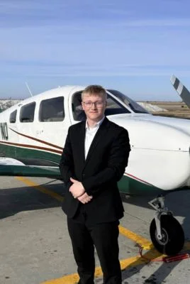 Bennett Eriksrud in front of a UND plane