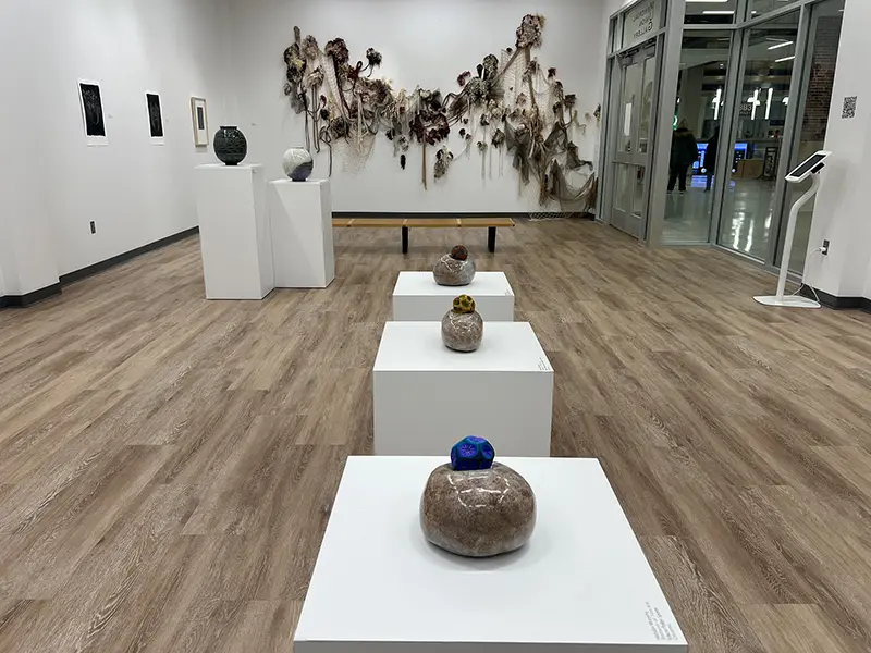 Pottery and netting are displayed in an art gallery.